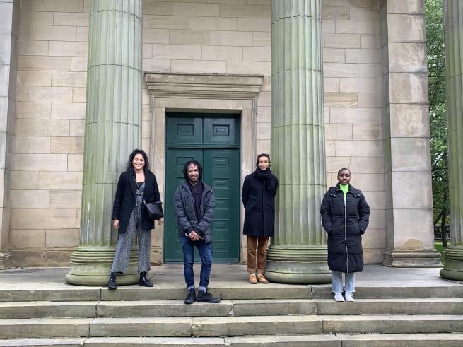 Four artists stood on the steps of a building