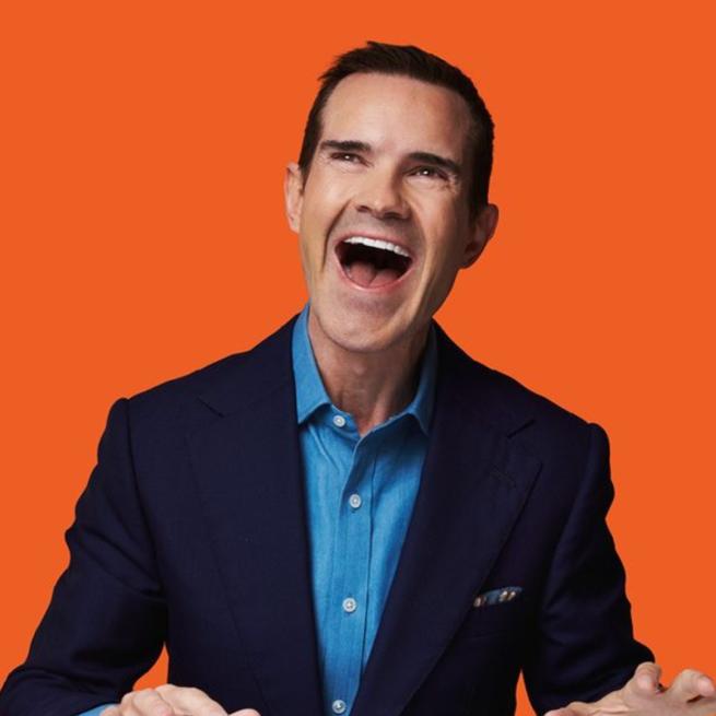 Jimmy Carr laughing with an orange background.