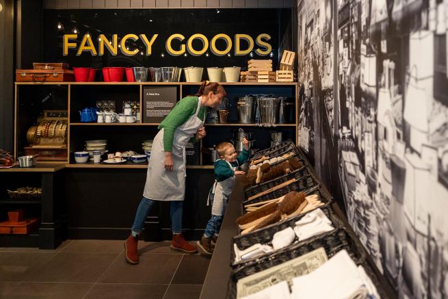A colour photo of a parent and child playing in a replica shop