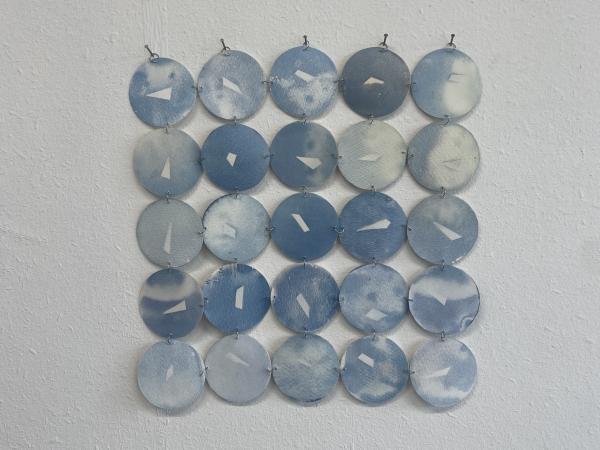 A grid of blue circular cyanotype prints