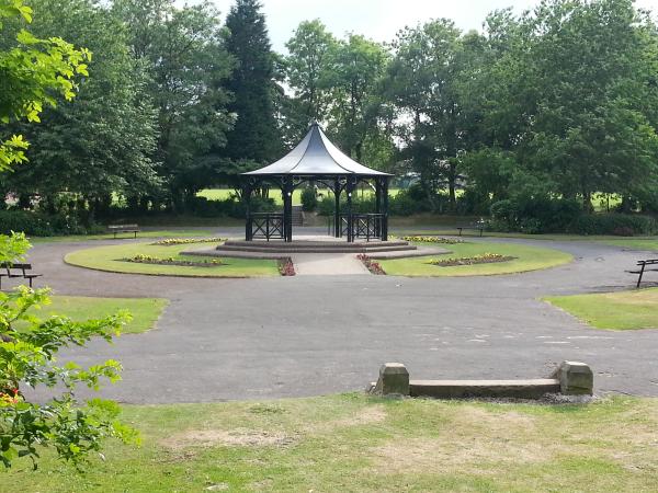 A bandstand in the middle of a park. 
