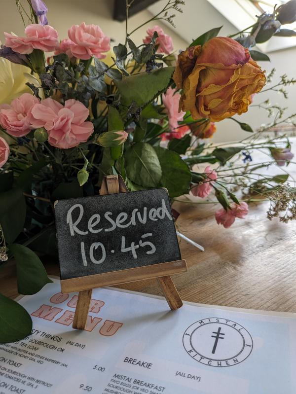 A reserved sign with flowers sat on a menu