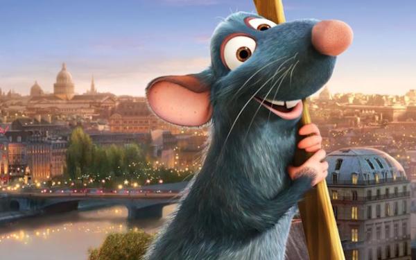 An animated rat holding a spoon stood in front of the Eiffel Tower.