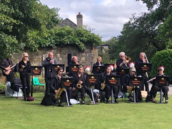 Sundown Swing performing outside in the park. 