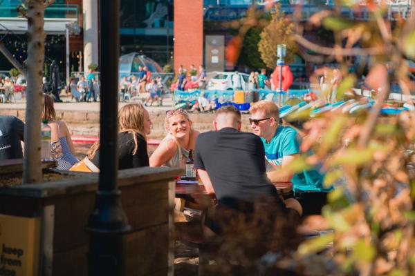 People outside waterlane boat house enjoying drinks in the sun