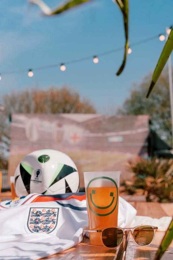 Football Shirt, a football, sunglasses, pint of beer on a table