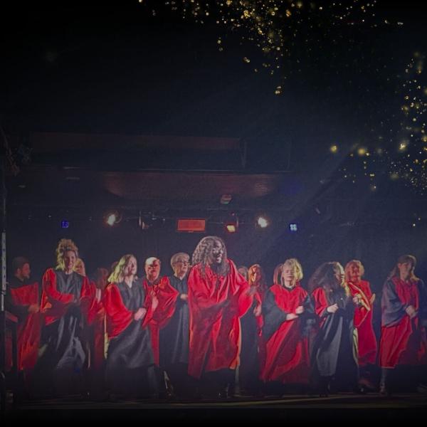 Members of the choir on stage in red choir robes.