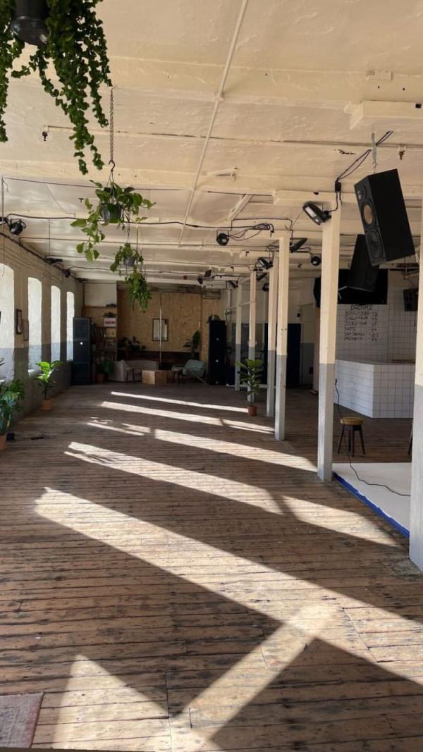 An image of the Sable studio event space, with wooden flooring, plants and large windows.