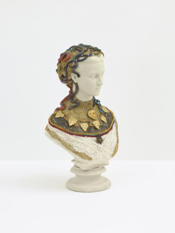 A classical style bust of a woman's head adorned with serpents, skulls and leaves
