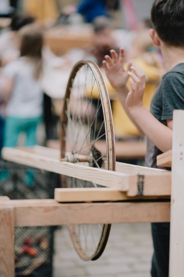 A happy boy playing with a spinning wheel outdoors.