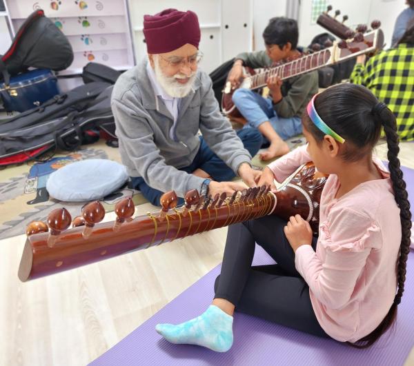 People holding the Indian instrument Sitar