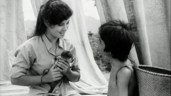 Woman hold a monkey as she talks to a child 