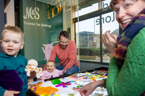 A colour photo of a family playing at a light table.