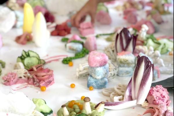 Food is layed out on a table in a playful manner.