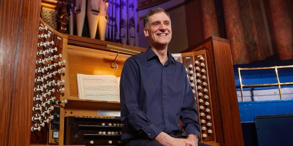 A musician sat on the organ bench. 