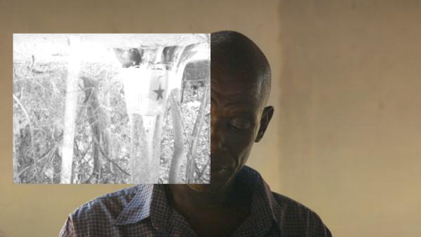 Head and shoulders of a man looking down with a black and white image covering half of his face.