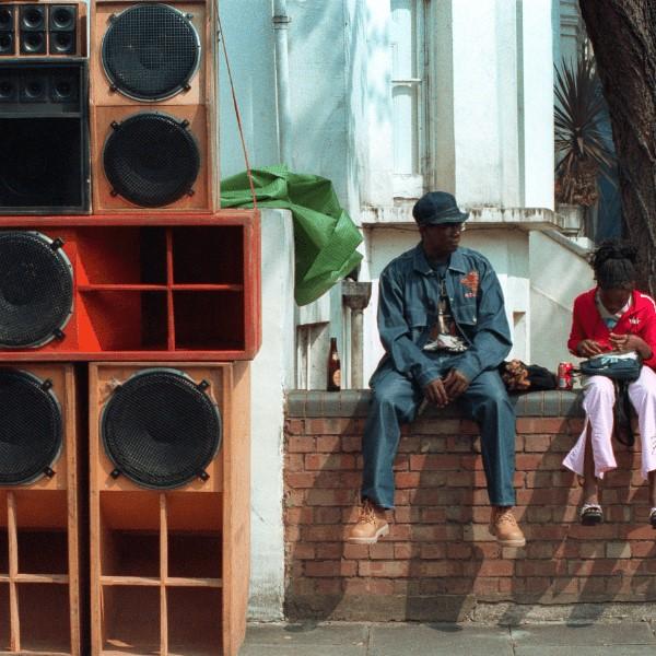 A man and a boy sitting next to a large sound system