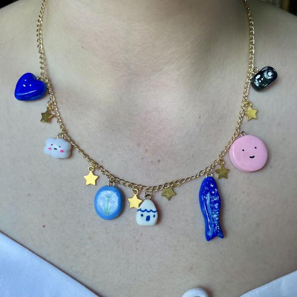 A gold necklace with colourful clay charms