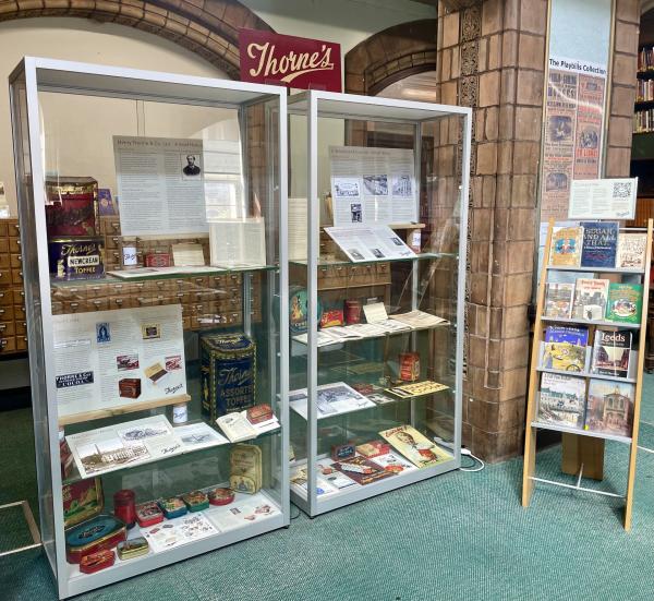 Colour photograph showing display cabinets in a traditional library setting