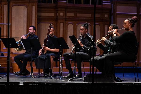 Musicians sat performing on a stage. 