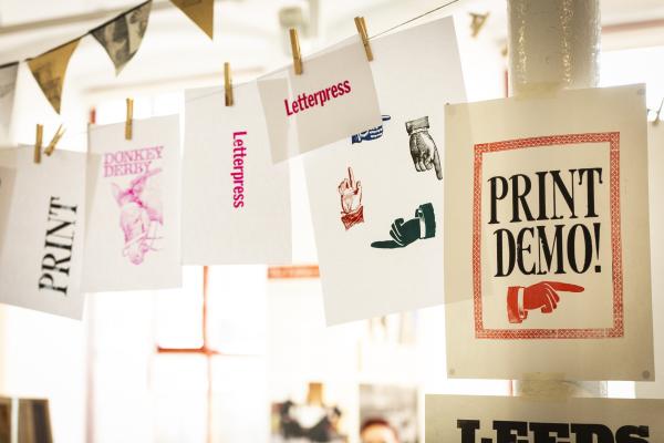 Letterpress printed posters hanging stating 'Print Demo' 