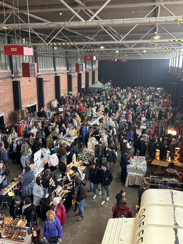 Overhead image showing a busy flea market with lots of people looking at craft and furniture stalls