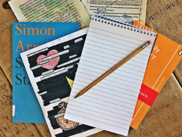 A pile of books topped with a notebook and pencil.