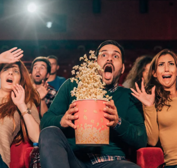 a picture of a movie audience jumping with popcorn flying in the air