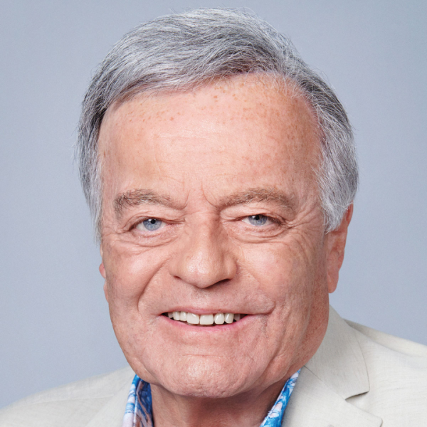 Headshot of Tony Blackburn smiling in a beige suit.