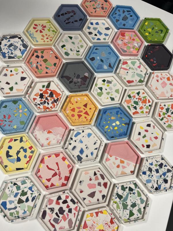 The image shows several hexagonal terrazzo coasters made out of Jesmonite