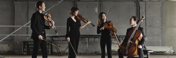 Four musicians holding string instruments about to start performing. 