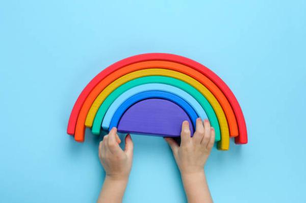 small hands playing with a rainbow toy