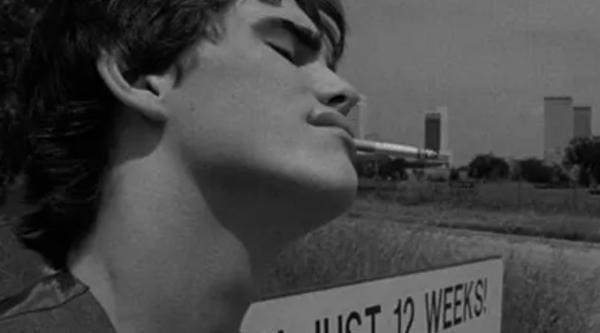 Matt Dillon as Rusty James smoking a cigarette in a black and white photo and a sign says just 12 weeks