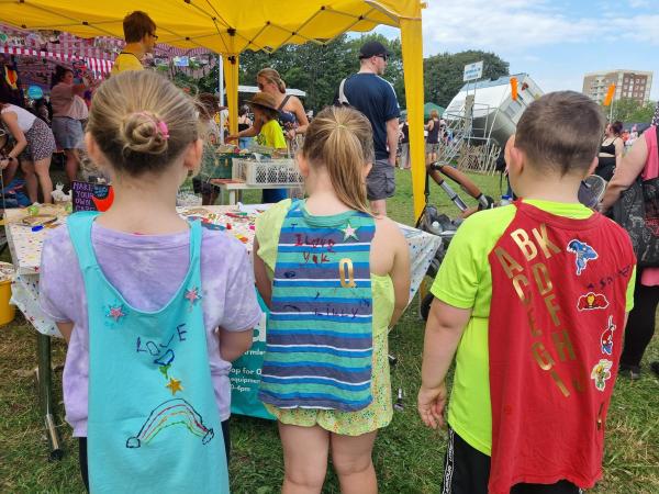 Photo of children making superhero capes with bundles at Armley Festival