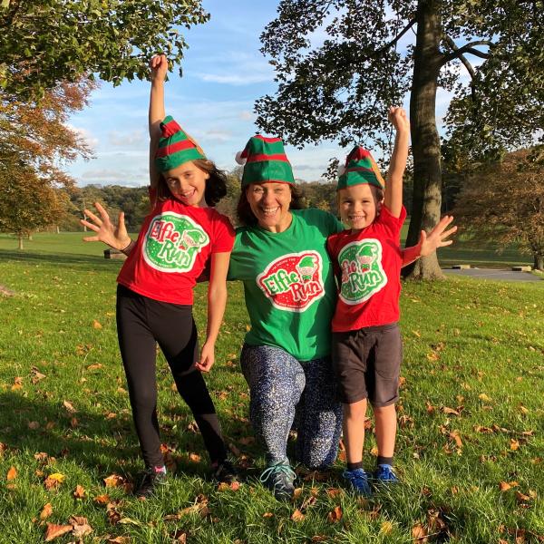 The image includes three participants wearing Elfie Run hats and Elfie Run T-shirts