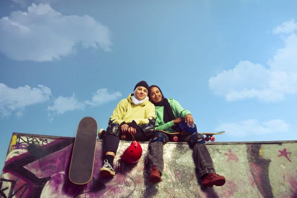 Two skaters smiling as they pose for a picture