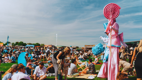 We're focused on a snapshot of last years busy North Leeds Food Festival whereby festival goers are lounged on deckchairs watching the live entertainment!