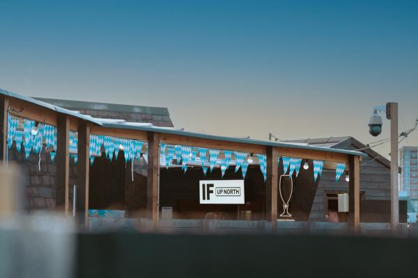 Image shows the Rooftop bar, as the sun sets with Oktoberfest decorations hanging from the roof. 