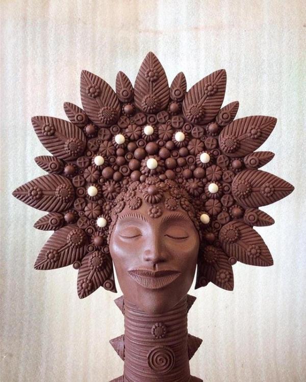 Folk-art image of woman's face in black clay