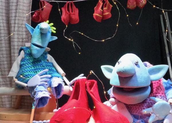 Elf puppets proudly show off their shoe creations