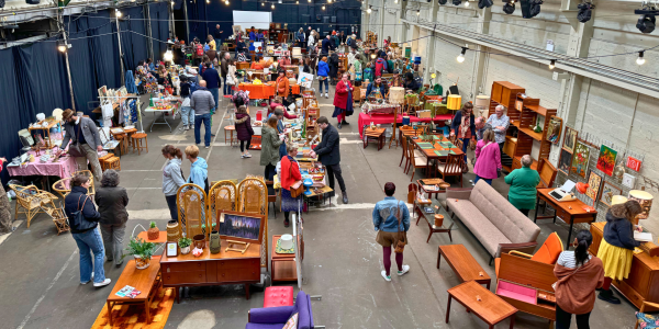 A market place filled with people shopping midcentury era homewares