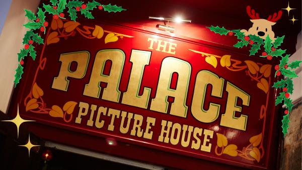 A sign for The Palace Picture House decorated with Christmas graphics