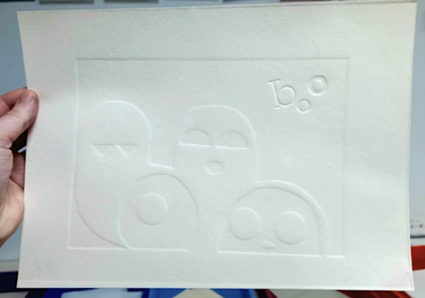 Graphic images of ghosts saying "Boo" embossed on white paper