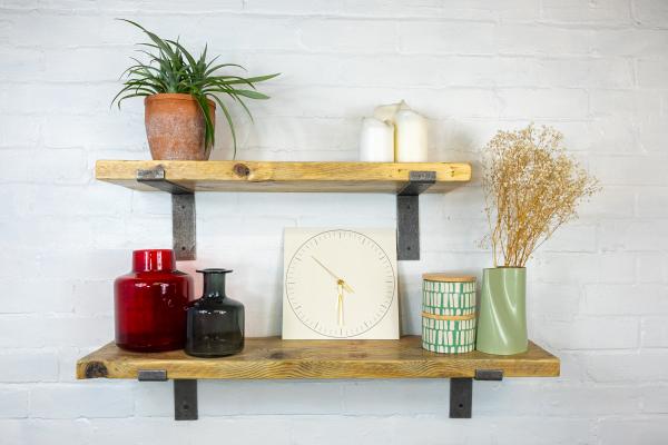 Image of scaffold board shelves with objects on including a plant, clock and vases