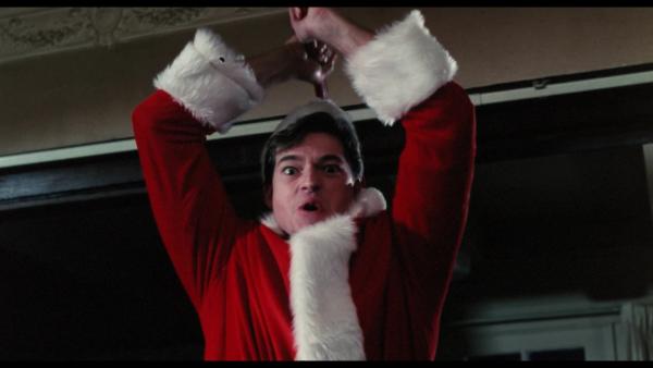 A man wearing a santa costume raises an axe above his head, with a maniacal expression on his face.