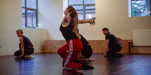 Four dancers in a crouching position