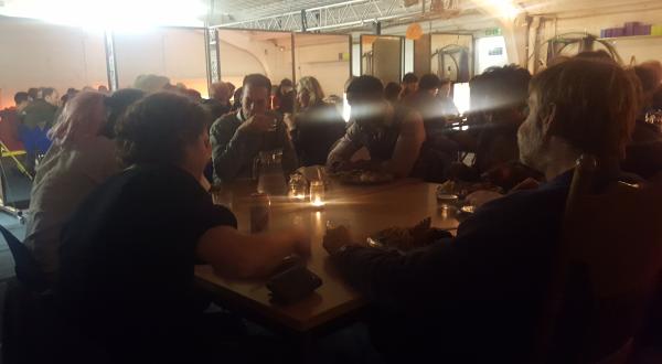 A sparkly darkened room full of people sitting down around big tables