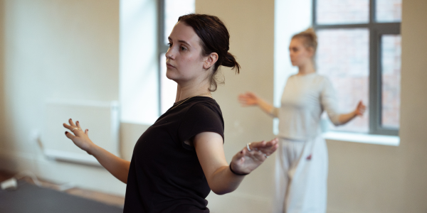 Two dancers with their arms out 