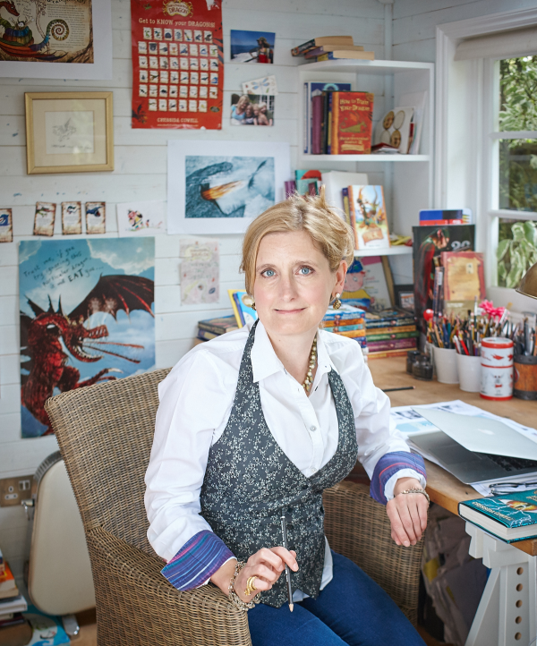 Author Cressida Cowell sat at her writing desk surrounded by pictures and stationery