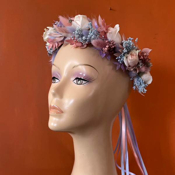 Mannequin head wearing flower crown made with pink, purple and blue dried and fresh flowers